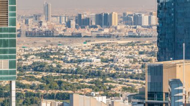 Dubai marinası ve JLT gökdelenleri. Gün batımında villaların gökdelenleri. Çoklu yüksek kulelerin büyük perspektifi. Binaların üzerinde güneş ışığı. Birleşik Arap Emirlikleri.
