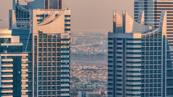 Dubai marina and JLT skyscrapers aerial skyline during sunset timelapse. Great perspective of multiple tallest towers. Sunlight over buildings. United Arab Emirates.