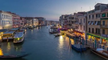 Grand Canal in Venice, Italy day to night transition timelapse. Panoramic view on gondolas and city lights from Rialto Bridge. Beautiful and romantic Italian city on water.