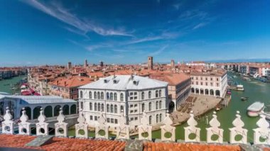 Top panoramic view on central busy canal in Venice timelapse, on both sides masterpieces of Venetian architecture, sailing on gondolas and boats. Blue cloudy sky at summer day over red roofs