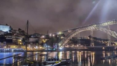 Porto, Portekiz 'in eski kasabası gece Douro Nehri' nin kıyısında, aydınlatılmış I. Luis Köprüsü zaman atlamalı haham tekneleriyle birlikte. Şehir ışıkları suya yansıyor