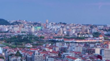 Panoramic aerial view on Rooftops of Portos old town on a warm spring evening timelapse day to night transition from above, Porto, Portugal. Lights turning on on the streets with traffic