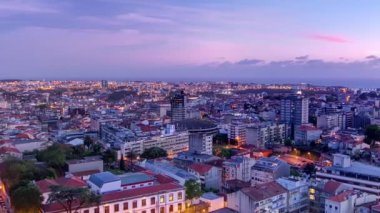Panoramic aerial overview on Rooftops of Portos old town on a warm spring evening timelapse day to night transition from above, Porto, Portugal. Lights turning on