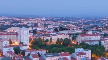 Aerial view on Rooftops of Portos old town on a warm spring evening timelapse day to night transition from above, Porto, Portugal. Lights turning on