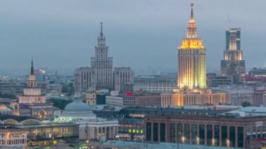 Moskova, Rusya 'daki Komsomolskaya meydanındaki Stalin gökdelenlerini ve üç tren istasyonunu gece gündüz yakından görüyoruz. Çatıdan hava görüntüsü.