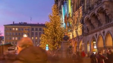 Balık Fıskiyesi, Fischbrunnen Marienplatz 'daki Yeni Belediye Binası önünde günden geceye geçiş zamanı Almanya' nın Münih şehrinde gün batımından sonra aydınlatılan tarihi merkez meydanı.
