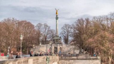 Barış Sütunu 'nda altın barış meleği heykeli Friedensengel zaman dilimi, Isar nehri üzerindeki köprüde ip cambazı arayan insanlar. Bavyera 'nın başkentinde halka açık bir park. Almanya, Münih, Bogenhausen