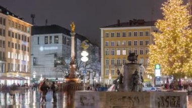 Balık Fıskiyesi, Fischbrunnen Marienplatz 'daki Yeni Belediye Binası' nın önündeki tarihi merkez meydanı, Almanya 'nın Münih kentinde akşam saatlerinde aydınlatıldı.
