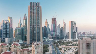 Şeyh Zayed Yolu 'nun Skyline manzarası ve Dubai, BAE' deki gece gündüz geçiş zamanı. Finansal merkezdeki aydınlık gökdelenler şehir merkezinin yukarısından gökyüzü manzarası