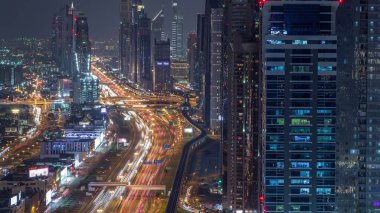 Dubai şehir merkezinde gökdelenler ve Şeyh Zayed yol gece timelapse, Dubai, Birleşik Arap Emirlikleri havadan görünümü. Modern kuleler ve karayolu üzerinde akşam trafiği