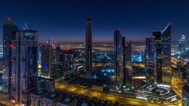 Dubai şehir merkezi finans merkezinde en yüksek gökdelenler ve gündüz geçiş timelapse karayolu gece trafik ile silueti. Yukarıdan havadan görünüm
