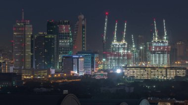 Dubai şehir merkezi mimarisi ile Aerial cityscape ve günlük geçiş timelapse, Birleşik Arap Emirlikleri finans merkezi gece. Şantiye ile en yüksek kuleler ve gökdelenler