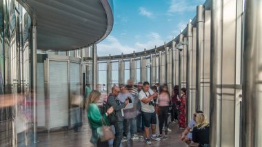 Turistler Burç Halife kulesi timelapse 125 katta gözlem güvertesinde gün doğumu buluşuyor. Kalabalık yukarıdan fotoğraf çekiyor