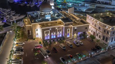 Dubai Marina 'daki yatlar Al Rahim Camii tarafından çevrelenmiş araba parkı ve konut kuleleri gece gündüz geçiş zamanı. Tekneler ve ahşap çayırlarla modern gökdelenler.