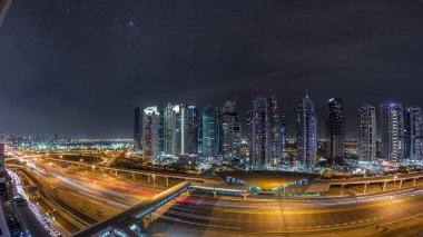 Dubai Marina 'dan Şeyh Zayed yoluna giden hava panoramik manzaralı Jlt aydınlatmalı gökdelenler, gece zaman çizelgesi, Dubai. Tramvaylı trafik, köprüler ve metro hattı. Birleşik Arap Emirlikleri