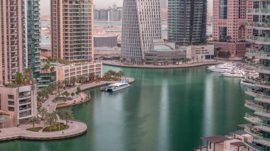 Dubai Marina Havaalanı 'ndaki gökdelenlerle dolu bir rıhtım gezisi. Kanalda yüzen tekne ve yatlar. Dubai, Birleşik Arap Emirlikleri