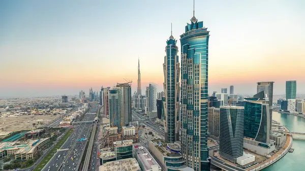 Dubai, Bae gece geçiş timelapse için şeyh zayed yol gün modern gökdelenler ve trafik ile Akşam silueti. İş koyu mimarisinin havadan görünümü.