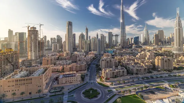Dubai Downtown skyline timelapse with Burj Khalifa and other towers panoramic view from the top in Dubai, United Arab Emirates. Traditional and modern buildings. Traffic on circle road and fountains