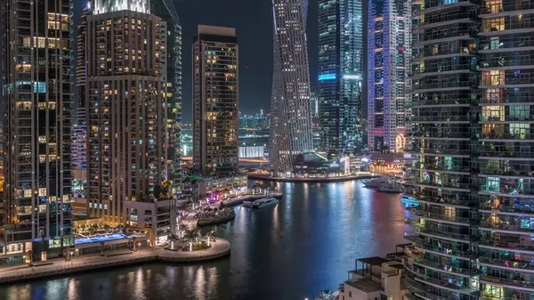 Dubai Marina yerleşim ve ofis gökdelenlerinin havadan görüntüsü. Palmiye ağaçlarının olduğu gece. Yüzen tekneler ve yatlar