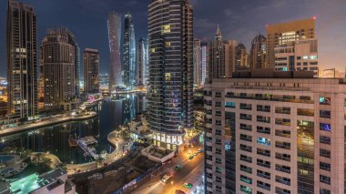 Dubai Marina yerleşim yerlerinin ve ofis gökdelenlerinin hava panoramik görüntüsü. Gün doğmadan önce gece gündüz geçiş zamanı. Yüzen tekneler ve yatlar