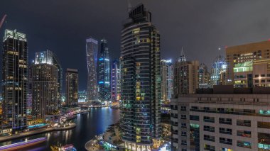 Dubai Marina yerleşim ve ofis gökdelenlerinin deniz kıyısına bakan zaman aralıklı görüntüsü. Yüzen tekneler ve yatlar