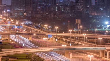 Dubai Golf Sahası 'nın arka planda yeşillik ve tekom bölgelerinden oluşan bir manzarası var. Gece gündüz geçiş zamanı. Şeyh zayed yolunda trafik kesişiyor.