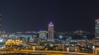 Dubai medya kenti aydınlatılmış gökdelenler ve golf sahası gece timelapse, Dubai, Birleşik Arap Emirlikleri. Yolda trafik ile Yeşiller bölgesinden havadan görünüm
