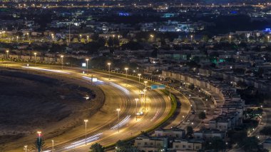 Golf sahası gece hızlandırılmış villa ve evlere havadan görünümü. Kavşaktaki trafik. Çeşmeli göller