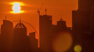 Dubai Marina gökdelenler golf sahası gün batımı timelapse, Dubai, Birleşik Arap Emirlikleri. Greens bölgesinden havadan görünüm. Yakından görünüm ve turuncu gökyüzü