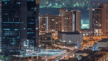 Jumeirah Lake Towers yerleşim bölgesi Dubai Marina yakınında hava gece timelapse. Işıklı modern gökdelenler ve yukarıdan trafik
