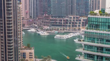 Dubai Marina yerleşim yerlerinin ve ofis gökdelenlerinin havadan görüntüsü. Rıhtımdan geceye geçiş zamanı. Yüzen tekneler ve yatlar