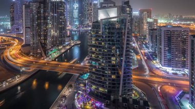 Dubai Marina konutlarının ve ofis gökdelenlerinin tüm gece boyunca liman manzarası ve yanıp sönen ışıklar. Yüzen tekneler ve yatlar