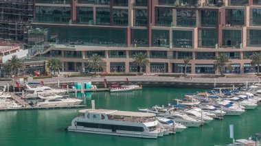 Dubai Marina Limanı 'ndaki rıhtım güvertesi, zaman ayarlı. Kanalda yüzen tekne ve yatlar. Dubai, Birleşik Arap Emirlikleri