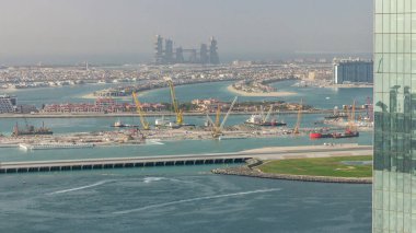 Palm Jumeirah adam havadan görünümü gün batımı zaman atlamalı önce Jbr ilçesinden ada yaptı. Dubai, Bae. Tekne ve yatlarla yeni liman terminalinin şantiyesi