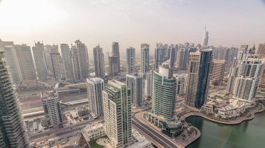 Dubai Marina ve Jlt sabah timelapse havadan üst görünümü. Dubai, Bae gün doğumundan sonra yüzen yatlar ve tekneler ile gezinti ve kanal. Modern kuleler ve yolda trafik