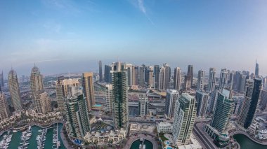 Dubai Marina'nın havadan üstten gündüz geceye geçiş saati. Dubai, Bae gün batımından sonra yüzen yatlar ve tekneler ile gezinti ve kanal. Işıklı modern kuleler ve yolda trafik