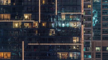 Gece timelapse kentsel ortamda modern çoklu katlı binanın pencerelerde ışıklar. Dubai Marina konut gökdelenparlayan ışıklar