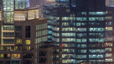 Gece timelapse kentsel ortamda modern çoklu katlı ofis binasının pencerelerde ışıklar. Dubai Marina konut gökdelenparlayan ışıklar