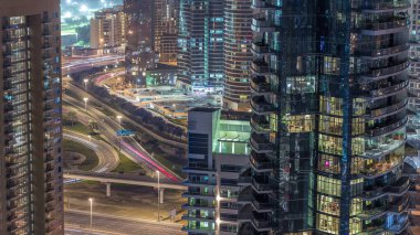 Büyük bir şehirde gece zaman atlamalı bir yol kavşağı havadan görünümü. Araba ve metro ile Bae Dubai Marina ve Jlt ilçe Kentsel manzara