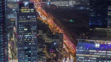 Al Saada caddesinde, Dubai, BAE 'deki DIFC gece zaman çizelgesi yakınlarındaki kavşak trafiğinin Skyline görüntüsü. Finans merkezindeki gökdelenler şehir merkezindeki yukarıdan hava manzarası