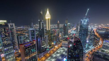 Dubai, BAE 'deki tüm gece boyunca Sheikh Zayed Yolu ve DIFC yakınlarındaki binaların panoramik silueti. Finansal merkezde ve şehir merkezinde aydınlık gökdelenler ve modern kuleler