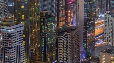 Sheikh Zayed Road ve Difc hava gece zaman aşımına Dubai, Bae yakınındaki binaların Silueti. Finans merkezi ve şehir merkezinde modern kuleler ve ışıklı gökdelenler