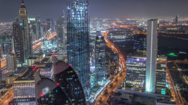 Sheikh Zayed Road ve Difc hava gece zaman aşımına dubai, Bae yakınındaki binaların panoramik silueti. Finans merkezi ve şehir merkezinde modern kuleler ve ışıklı gökdelenler