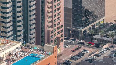 Çatı yüzme havuzu ile otopark yukarıda timelapse, Finans bölgesinde havadan üst görünümü manzaralı. İnsanlar rahatlıyor. Dubai, Birleşik Arap Emirlikleri