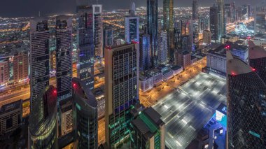 Sheikh Zayed Yolu yakınlarındaki binaların silueti ve Dubai, BAE 'deki hava trafiği gece gündüz değişiyor. Gündoğumundan önce finans merkezinde ve şehir merkezinde modern kuleler ve aydınlık gökdelenler