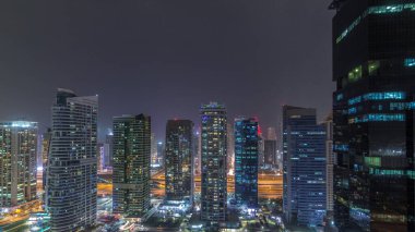 Jumeirah göl kuleleri ilçe dubai gece timelapse konut ve ofis binaları. Modern gökdelenler ile yukarıdan havadan panoramik görünüm