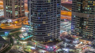 Jumeirah göl kuleleri konut ve ofis binaları dubai mağazalar, restoranlar ve yürüyüş yolları ile gece timelapse ilçe. Modern gökdelenler ile yukarıdan havadan panoramik görünüm