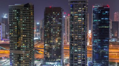 Jumeirah göl kuleleri ilçe dubai gece timelapse konut ve ofis binaları. Modern gökdelenler ile yukarıdan havadan panoramik görünüm