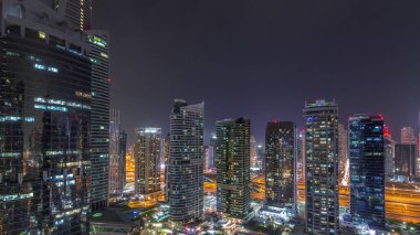 Dubai'de ışıkların kapalı olduğu tüm gece zaman diliminde Jumeirah gölü kuleleri semtindeki konut ve ofis binaları. Modern gökdelenler ile yukarıdan havadan panoramik görünüm