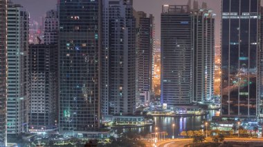 Jumeirah gölükuleleri konut ve ofis binaları Dubai'de gün doğumundan önce gündüz geçiş timelapse ilçe gece. Işıklı modern gökdelenler ile yukarıdan havadan panoramik görünüm